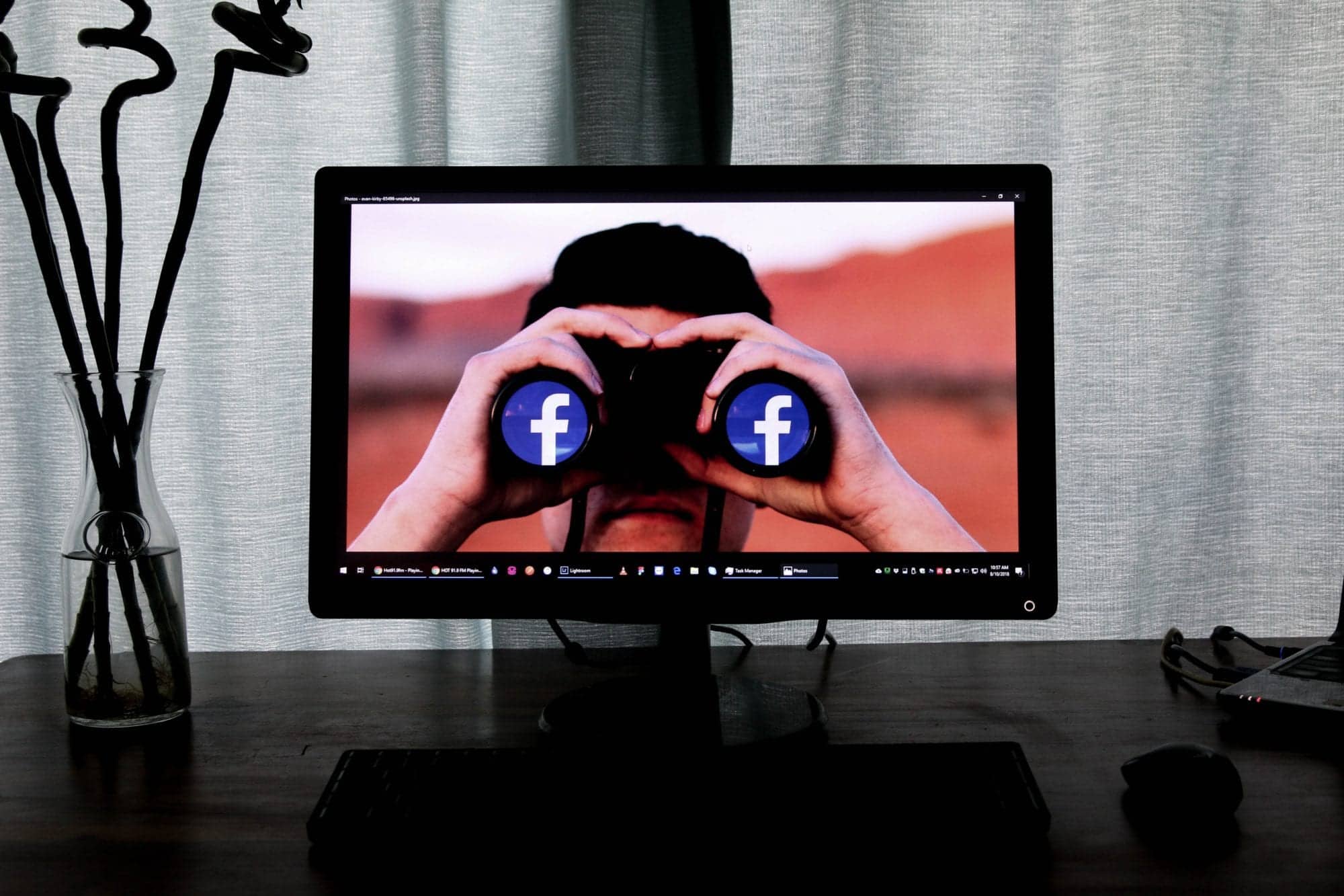 Man with safety binoculars looking at Facebook social media icons